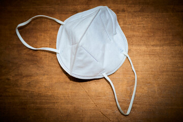 FFP2 mask as covid-19 protection. Coronavirus mask on grunge wooden table. Selective focus