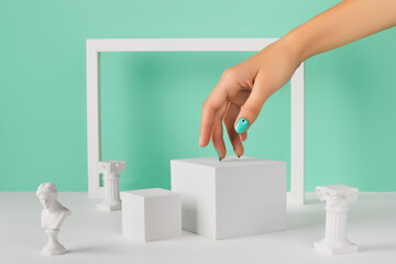 Womans hand podium and frame over turquoise background