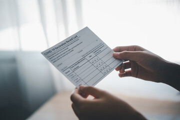 Naklejka premium Coronavirus vaccination record card is held in hand. patient who has already been vaccinated with Coronavirus .Coronavirus prevention 
