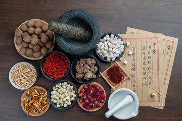 Ancient Chinese medicine books and herbs on the table