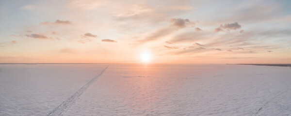 Ice on the frozen sea and bright colored sky at sunset