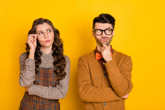 Portrait Of Attractive Puzzled Discontent Couple Touching Specs Overthinking Solution Isolated On Bright Yellow Color Background