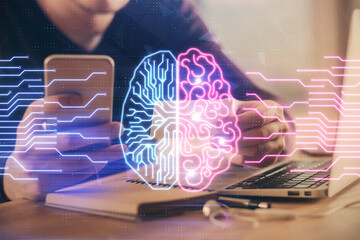 Double exposure of man's hand holding and using a digital device and brain hologram drawing. Data concept.