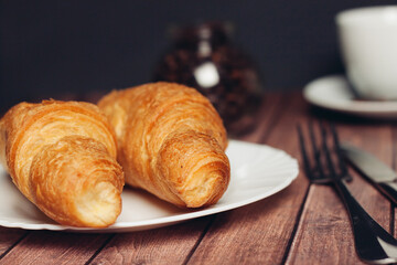 fresh croissants on a saucer table setting breakfast cup with drinks