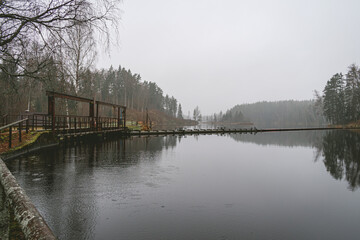 Fototapeta na wymiar Braslas reservoir and hydroelectric station surrounded by a beatiful pine tree forest in Latvia during cloudy day