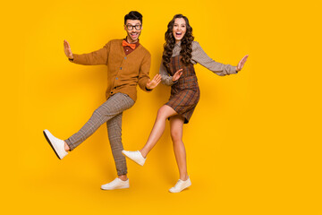 Full size photo of happy funky couple boyfriend girlfriend dance good mood isolated on yellow color background