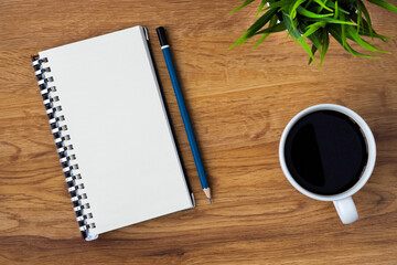 Fototapeta na wymiar Top view of open school notebook with blank pages, coffee cup and pencil for taking write notes on table background. Flat lay, creative workspace office. Business-education concept with copy space.