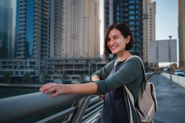 Happy young female traveler in the big city of Dubai, UAE