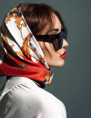 glamorous woman in black sunglasses with red lips and head scarf