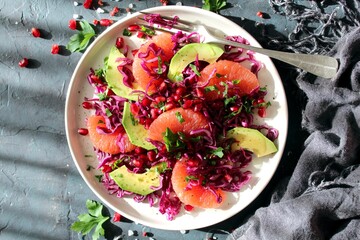 Red cabbage salad with avocado, grapefruit and pomegranate. Diet food. Top view.