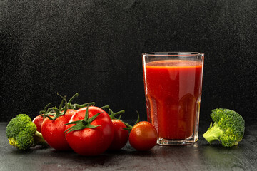 Tomato and tomato juice on black background