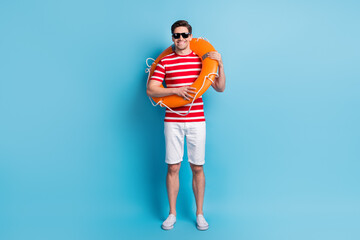 Full length body photo man wearing orange circle chilling on beach isolated on vibrant blue color background