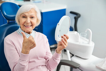 Elderly lady feeling pleased with the state of her teeth