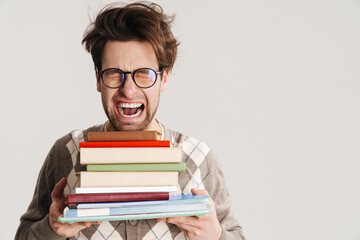 Shocked nerdy man holding stack of books isolated