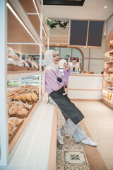 beautiful young woman hijab smiling proudly at her shop. attractive asian young female shopkeeper