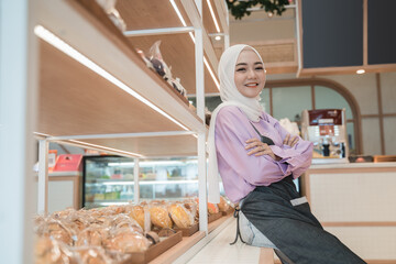 beautiful young woman hijab smiling proudly at her shop. attractive asian young female shopkeeper