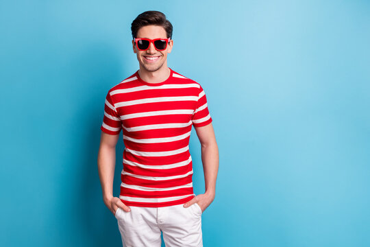 Photo portrait of young man smiling wearing stylish sunglass striped t-shirt shots isolated on vivid blue color background blank space