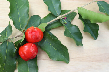 Thai cherry fruits fresh with green leaves isolated on wooden background closeup.