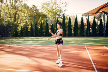 Fototapeta na wymiar Beautiful and stylish girl on the tennis court