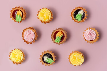 Tasty cupcakes pattern on pink background. vanilla cupcakes with pink and yellow cream.