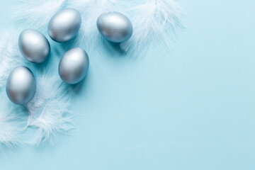 Silver Easter eggs with white feather. Easter decoration, top view