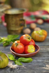 Fresh tomatoes and basil on wooden table over bokeh background