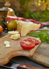 Tomatoes, garlic, basil and cheese parmigiano on an old authentic table. Fresh homemade ingredients