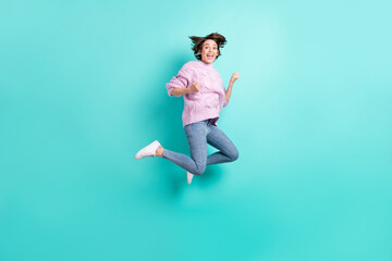 Full length photo of lucky charming young lady dressed purple pullover jumping high rising fists isolated teal color background