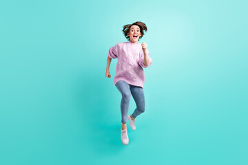 Fototapeta na wymiar Full length photo of pretty funky young lady dressed purple pullover jumping running isolated teal color background