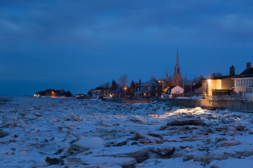 The St. Lawrence River’s icy coastline and Kamouraska village seen at dusk in winter, Quebec, Canada