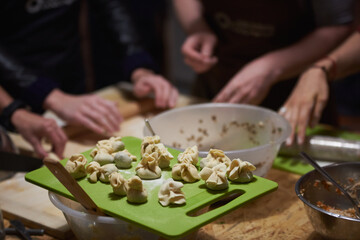 Obraz na płótnie Canvas Group of culinary passionate are forming and shaping dumplings 