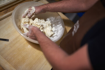 participant of culinary workshops mix flour and eggs to knead dough