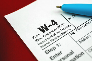 W-4 tax witholding form close up background with pen