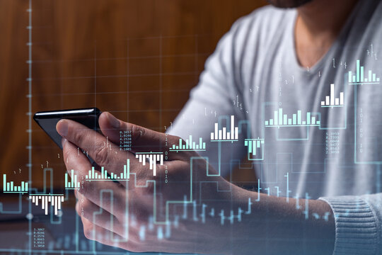 Trader holding in the hands a smart phone and researching stock market to proceed right investment solutions. Internet trading and wealth management concept. Hologram Forex chart over close up shot. - Powered by Adobe