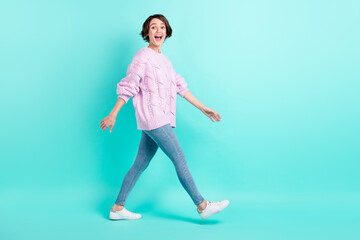 Fototapeta na wymiar Full length photo of adorable impressed young lady dressed purple pullover walking open mouth isolated teal color background