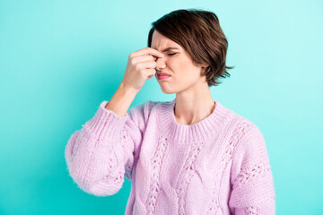 Photo of tired unhappy young lady dressed purple pullover closed eyes fingers nose isolated teal...