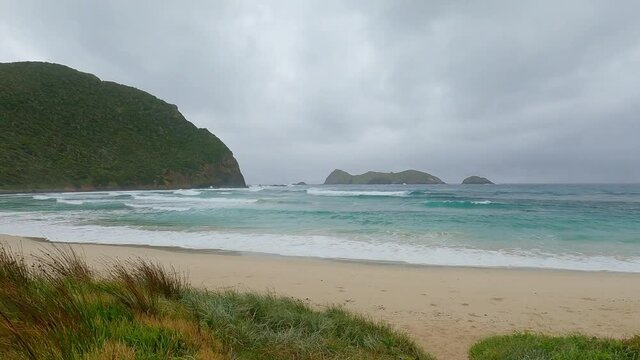 Walking over uneven terrain over grass and sand onto Ned&rsquo;s Beach with several beach in the foreground