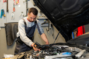Fototapeta na wymiar A professional car mechanic is changing an air filter, doing car service and maintenance of the vehicle. Oil and fuel filter changing. Service interval. 