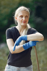 Woman collects leaves and cleans the park