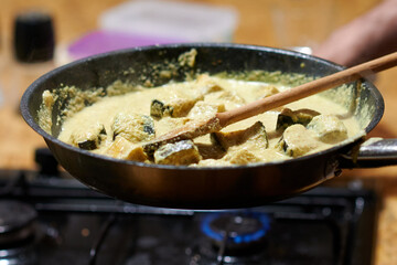 frying eggplant in sauce on a gas stove