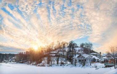 Wooden houses on the banks of the snow-covered Shokhonka River and Cathedral Mountain in Plyos