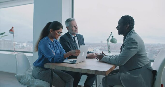 Couple managers looking through CV discussing details of agreement with potential candidate