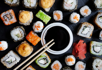 Set of sushi and maki on stone table.