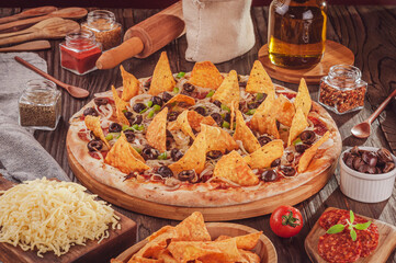 Pizza with mozzarella, onion, pepperoni, black olive, green peppers, nachos and oregano (Pizza mexicana)