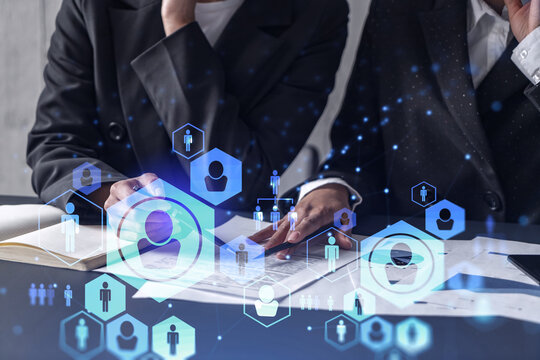 Two HR specialists analyzing the market of freshers to boost the intern program at international consulting company. Hiring new talented crew. Social media hologram icons. Women in business. - Powered by Adobe