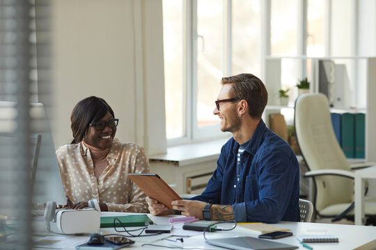 Smiling African American Woman Talking to Boss in Office - Powered by Adobe
