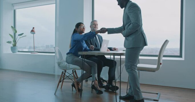 Couple of multi-ethnic business people doing handshake on job interview 