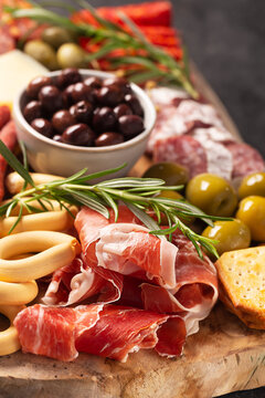 Charcuterie board with spanish jamon, pork sausage with pepper, fuet, cheese and berries