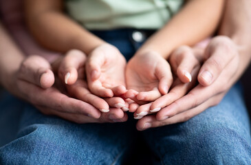 Parents and child placing their hands together, closeup shot