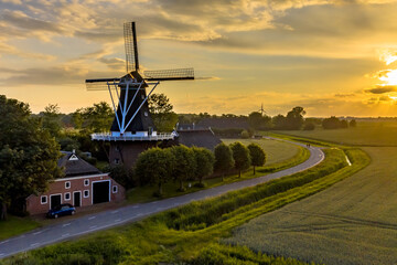 Historic windmill at a farm in agricultural landscape